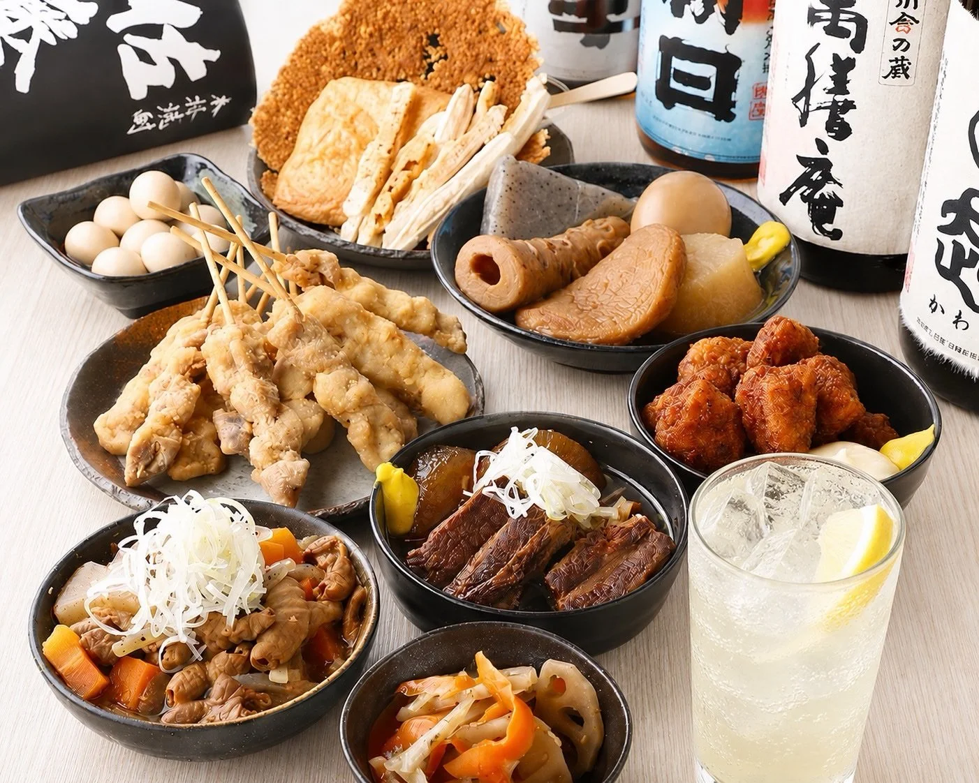 カウンター席の前に料理皿とジョッキが並び奥ににぎわう店内が見える横長写真